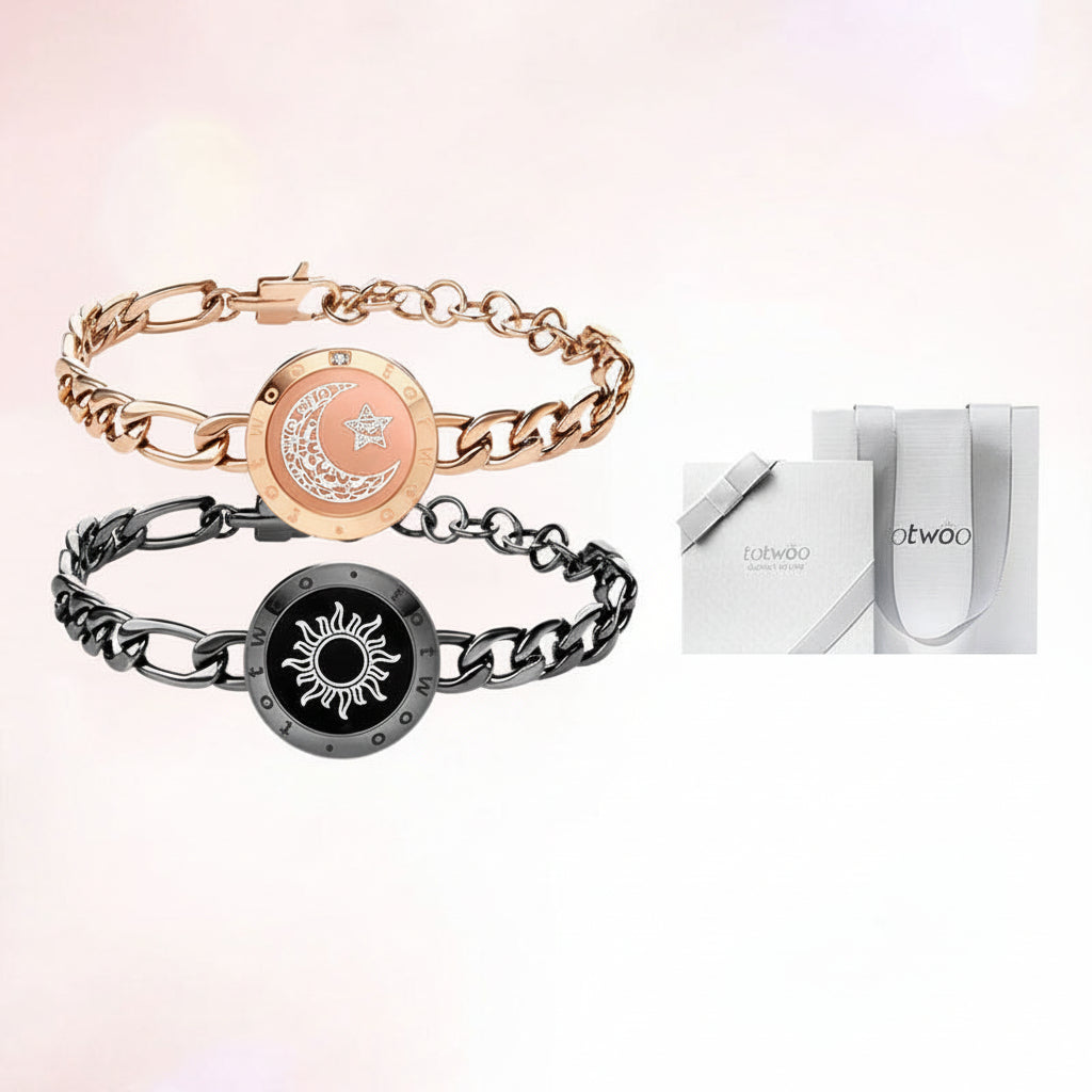 Two gold and black bracelets with on a light pink background.