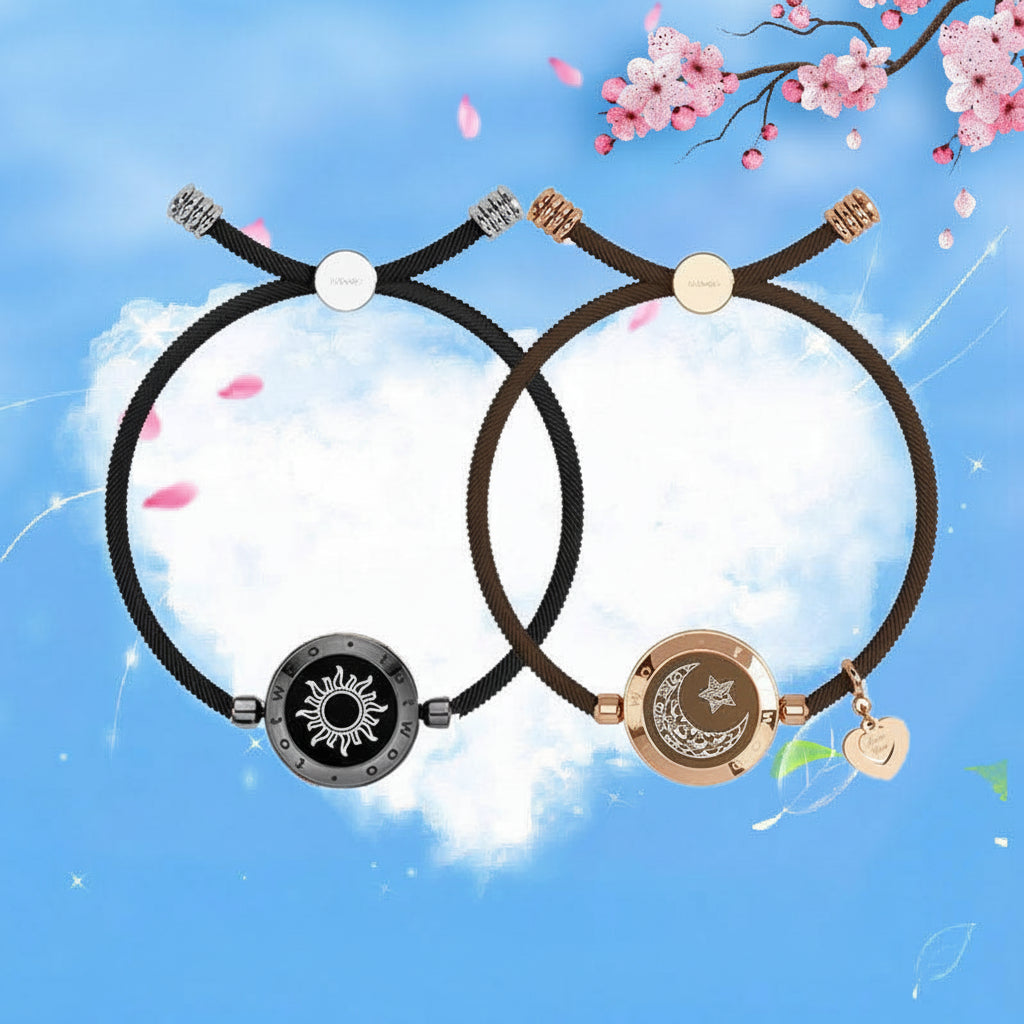 Two black bracelets with decorative ends on a blue background with cherry blossoms