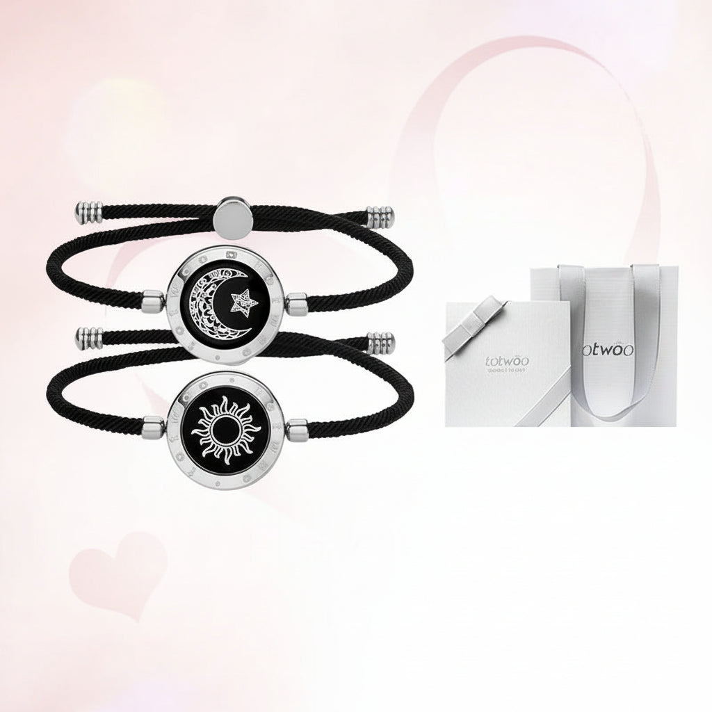 Two black and silver bracelets with celestial designs on a light pink background.